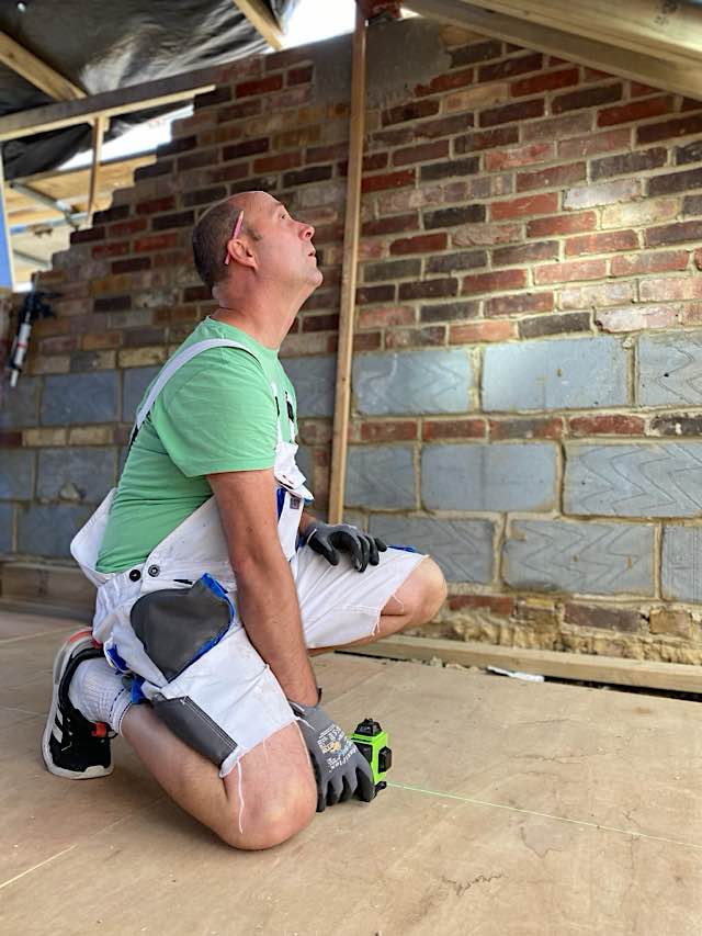 A expert builder working on a roof space.